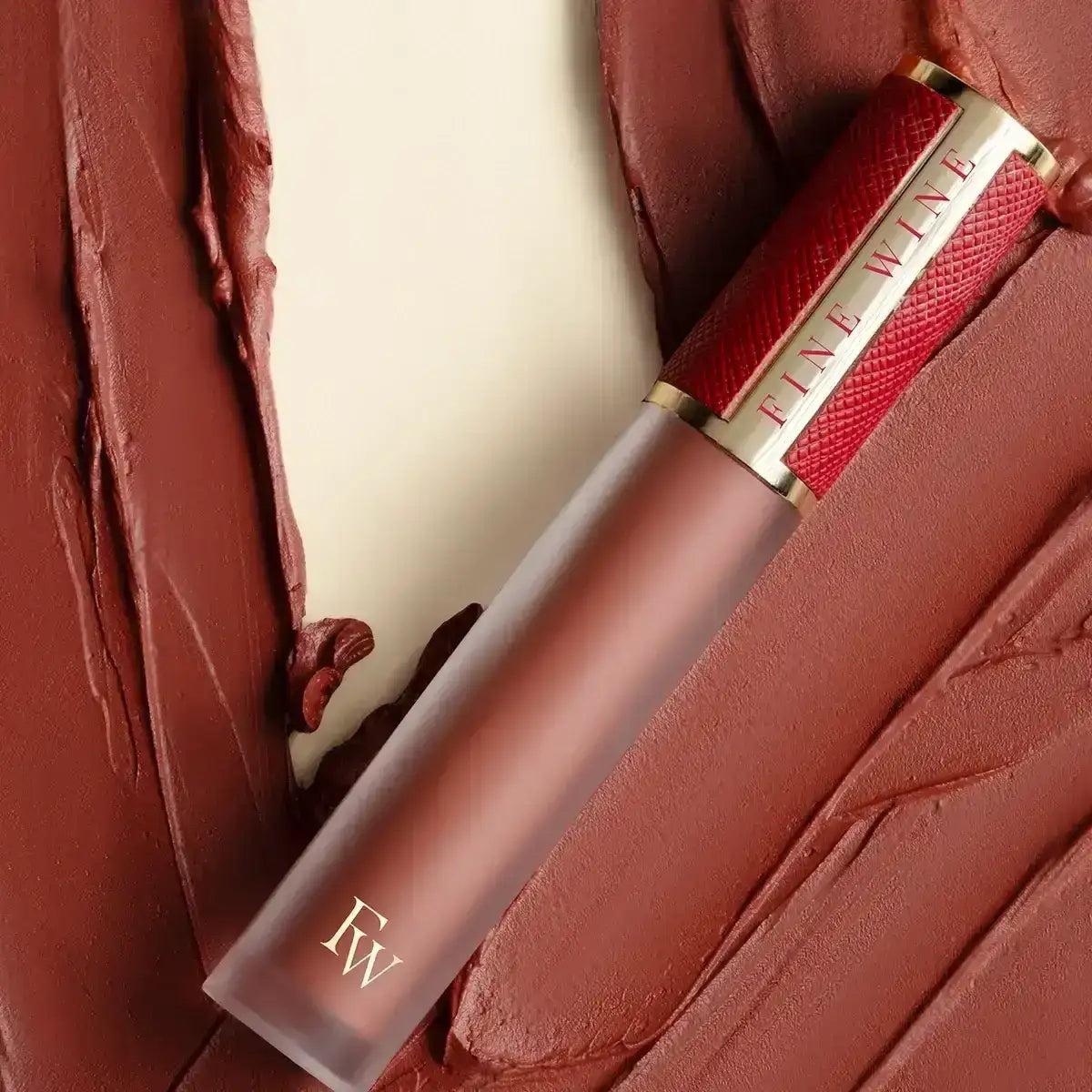 Brown-red lipstick tube with printed label and applicator tip