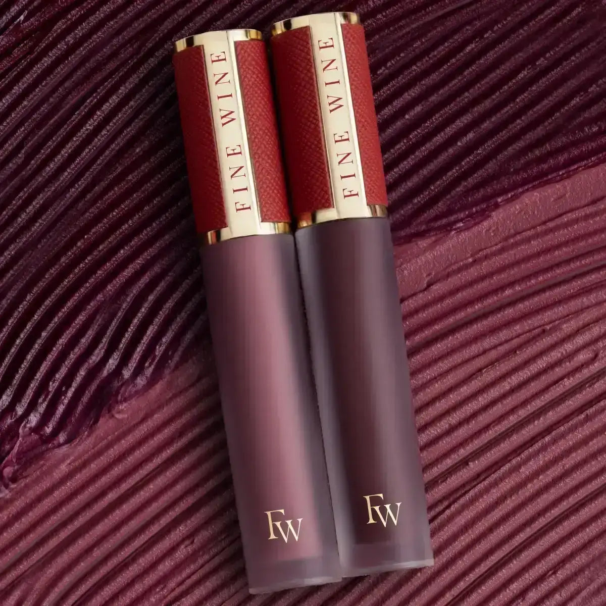 Mousse lipstick combo with two cylindrical tubes, burgundy and plum shades, gold caps