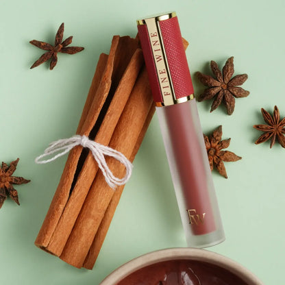 Red matte SPF lip mousse lipstick tube with clear container, product close-up